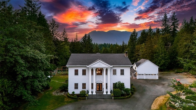 view of front of house with an outdoor structure, a garage, and a mountain view