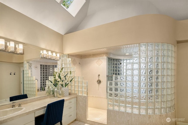 bathroom featuring tiled shower, tile patterned flooring, vaulted ceiling, and vanity