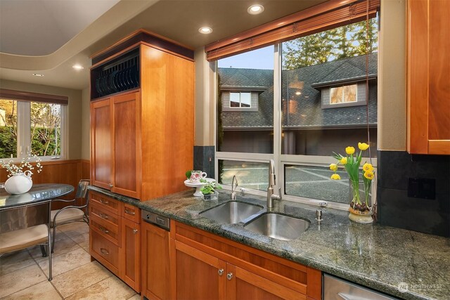 kitchen featuring sink, dark stone counters, and light tile patterned floors