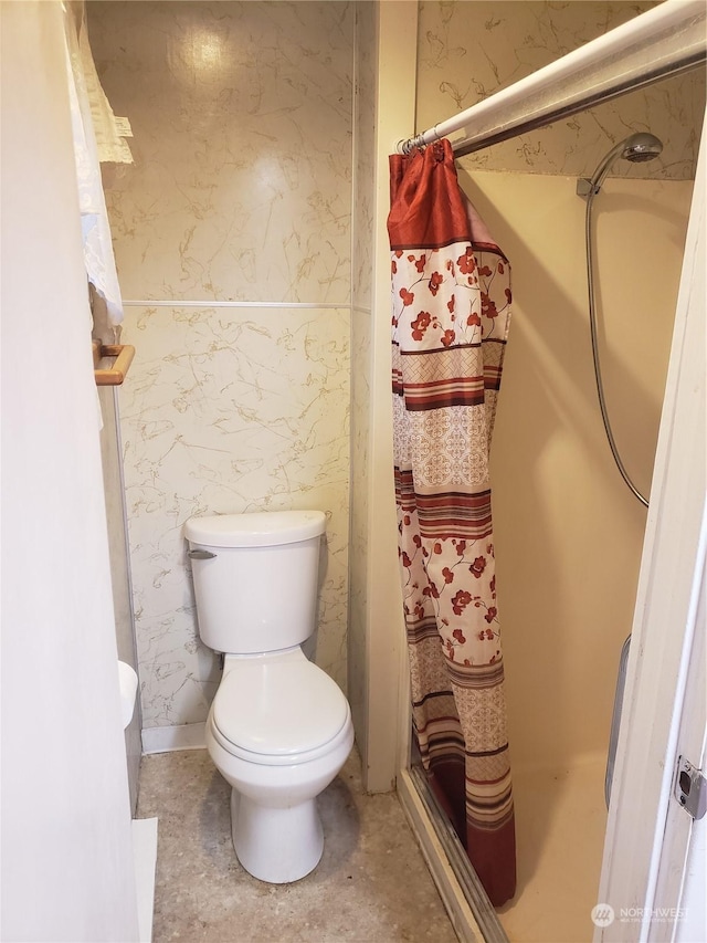 bathroom featuring a shower with curtain and toilet