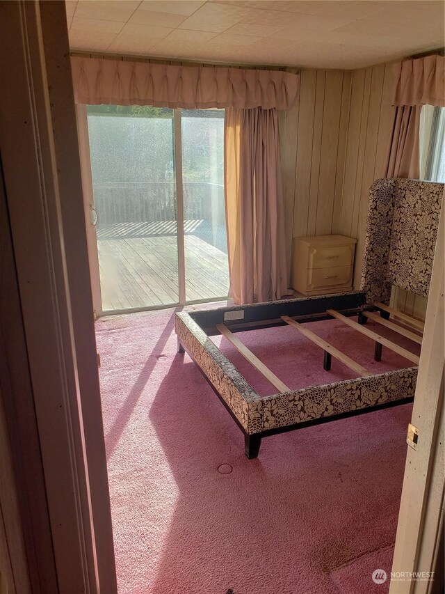 bedroom featuring wood walls and carpet flooring