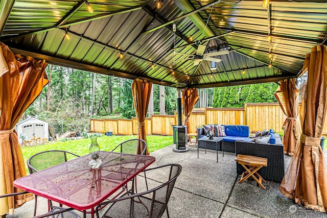 view of patio / terrace with a gazebo, a storage shed, ceiling fan, and an outdoor living space