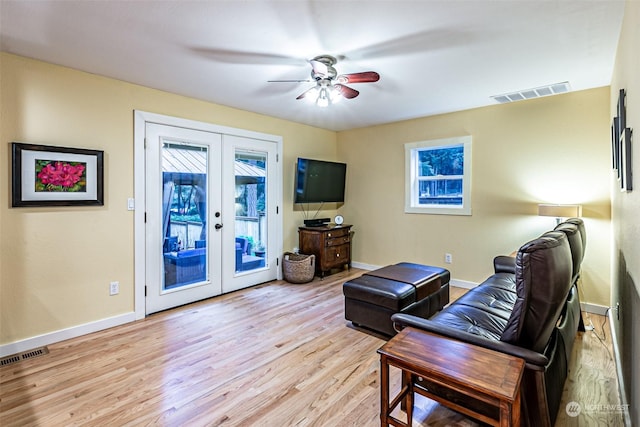 living room featuring light wood-type flooring, ceiling fan, and french doors