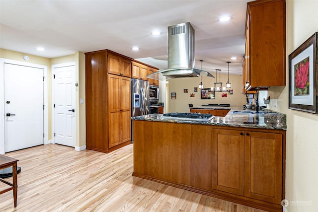 kitchen featuring stainless steel appliances, dark stone countertops, light hardwood / wood-style flooring, kitchen peninsula, and island range hood