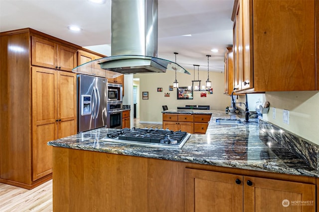 kitchen with kitchen peninsula, dark stone counters, island exhaust hood, and stainless steel appliances