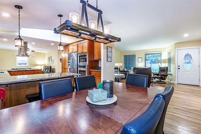 dining room with vaulted ceiling and light hardwood / wood-style flooring