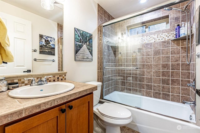 full bathroom with vanity, shower / bath combination with glass door, toilet, and tasteful backsplash