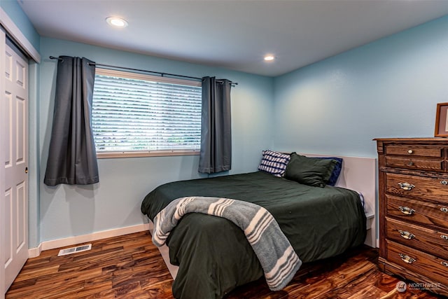 bedroom featuring a closet and dark hardwood / wood-style flooring