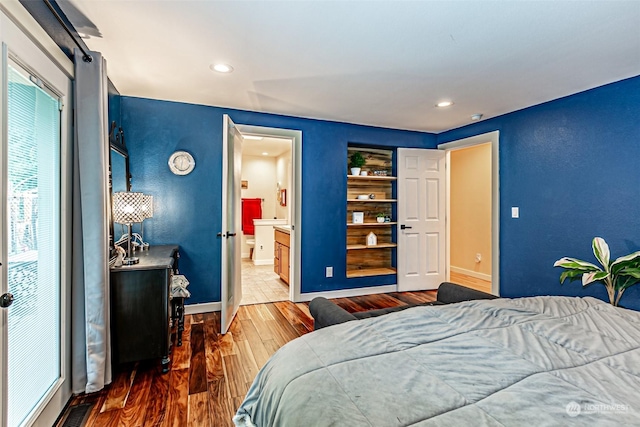 bedroom with wood-type flooring and connected bathroom