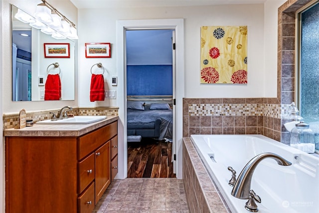 bathroom featuring vanity and a relaxing tiled tub