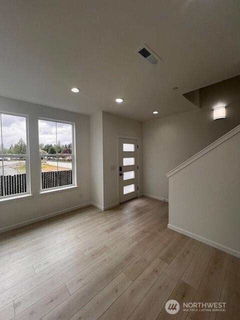 foyer with healthy amount of natural light, baseboards, light wood-style flooring, and recessed lighting