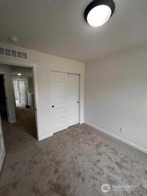 unfurnished bedroom featuring carpet, a closet, and baseboards