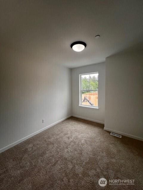 carpeted spare room featuring baseboards