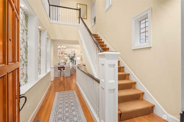 interior space with a high ceiling, hardwood / wood-style floors, and a chandelier