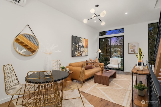 living room featuring an AC wall unit, hardwood / wood-style floors, and a notable chandelier