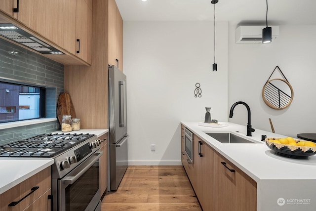 kitchen featuring backsplash, sink, appliances with stainless steel finishes, decorative light fixtures, and a wall unit AC