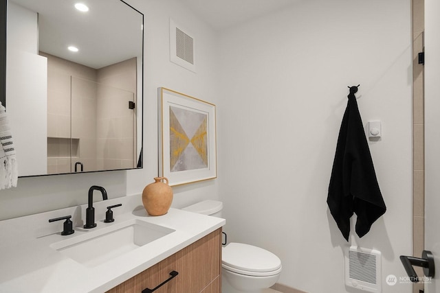 bathroom featuring walk in shower, heating unit, vanity, and toilet