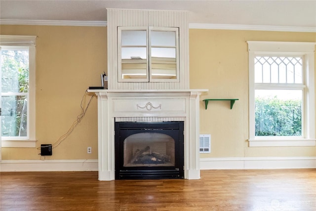 room details with a fireplace, crown molding, visible vents, and wood finished floors