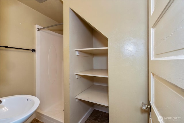 full bath featuring a shower stall, baseboards, and tile patterned floors