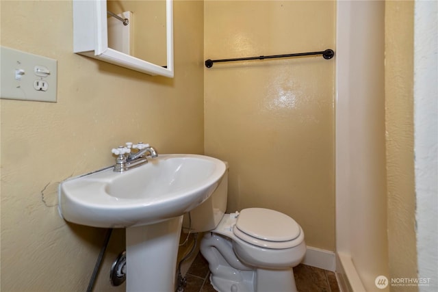 bathroom with toilet and baseboards