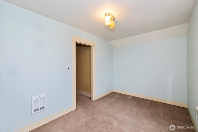 spare room with lofted ceiling, carpet floors, visible vents, and baseboards