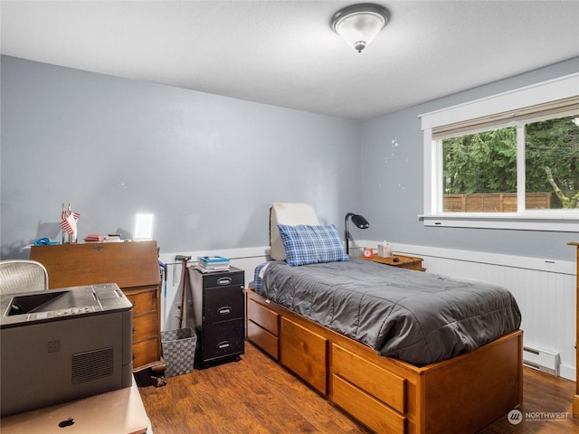 bedroom featuring a baseboard radiator and hardwood / wood-style floors