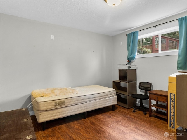 bedroom featuring wood-type flooring and a textured ceiling