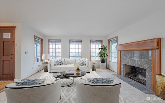 living room featuring a tiled fireplace and carpet floors