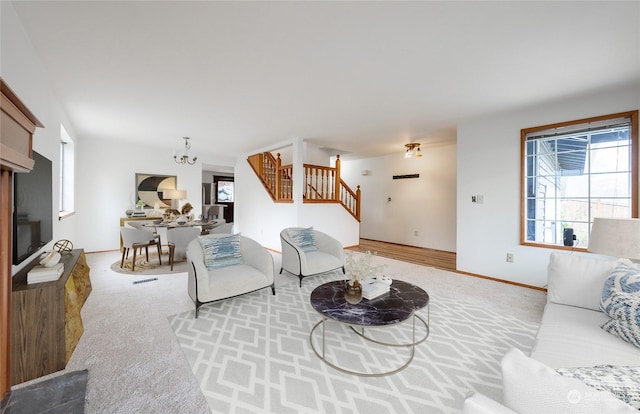 living room with an inviting chandelier, a healthy amount of sunlight, and light colored carpet