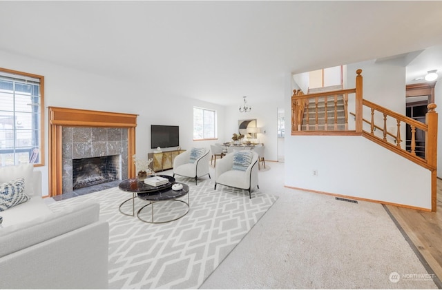 living room with a tiled fireplace and hardwood / wood-style flooring