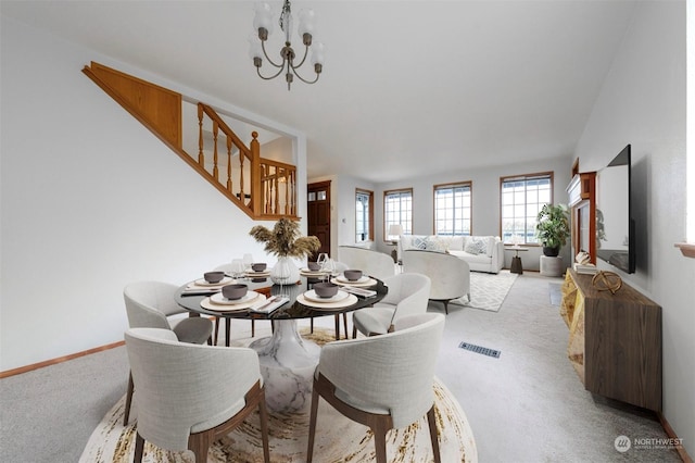 carpeted dining area with a notable chandelier