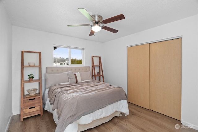 bedroom featuring a closet, ceiling fan, a textured ceiling, and light hardwood / wood-style flooring