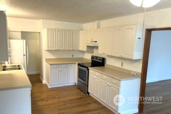 kitchen with electric stove, white cabinetry, dark hardwood / wood-style flooring, and a textured ceiling