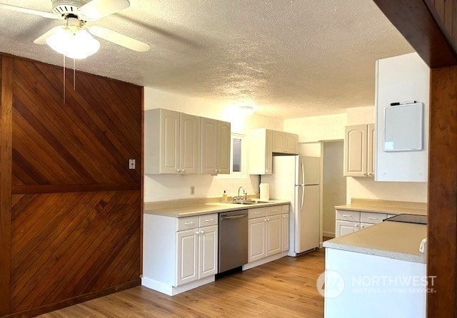 kitchen with white refrigerator, dishwasher, sink, and light wood-type flooring