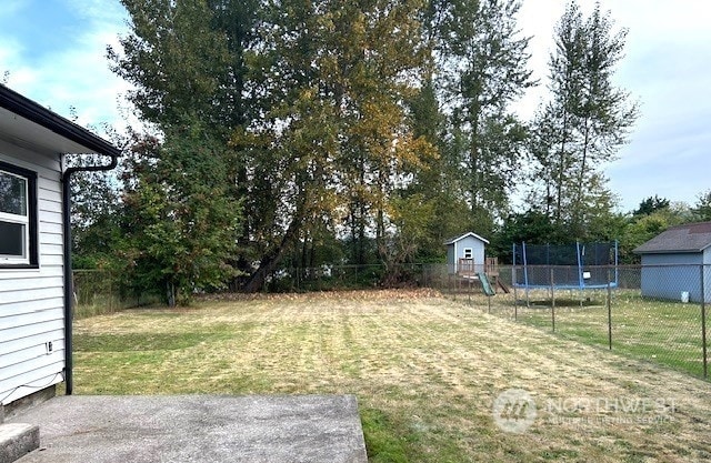 view of yard featuring a trampoline and a playground