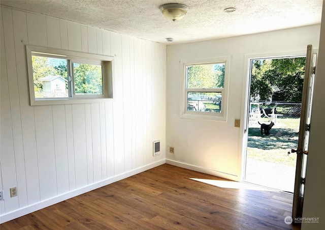 spare room featuring dark hardwood / wood-style flooring and a textured ceiling