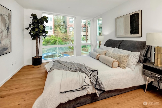 bedroom featuring multiple windows and hardwood / wood-style flooring