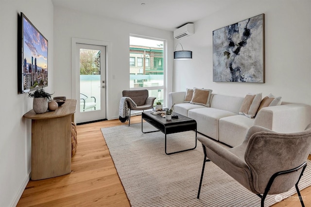 living room featuring an AC wall unit and light wood-type flooring