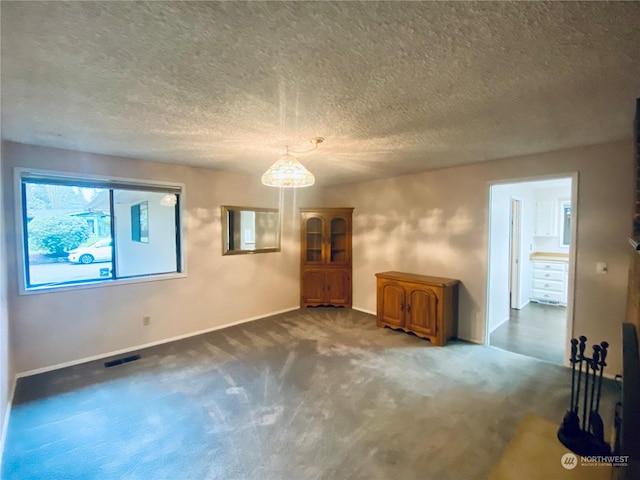 carpeted empty room featuring a textured ceiling