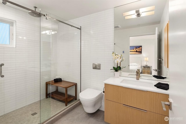 bathroom featuring toilet, tile patterned flooring, a shower with door, and vanity