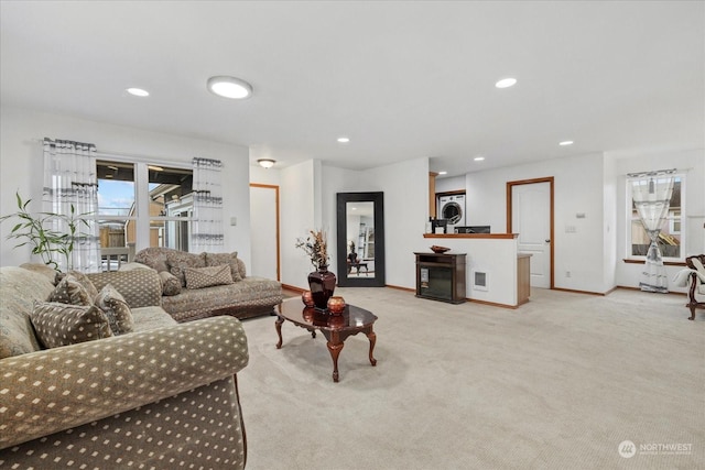 carpeted living room with stacked washer and clothes dryer