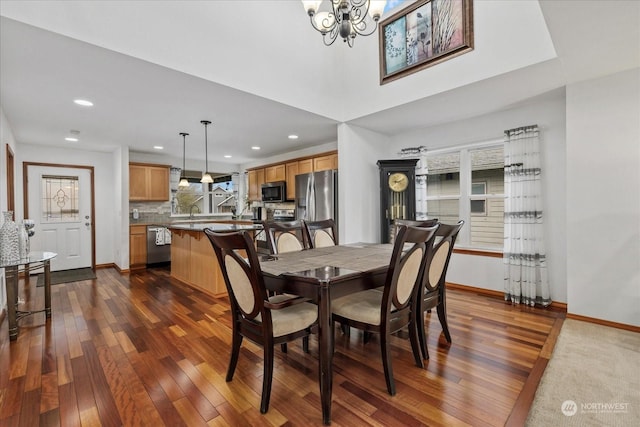 dining space with an inviting chandelier, dark hardwood / wood-style flooring, and sink