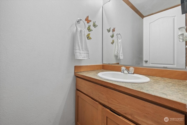 bathroom with ornamental molding and vanity