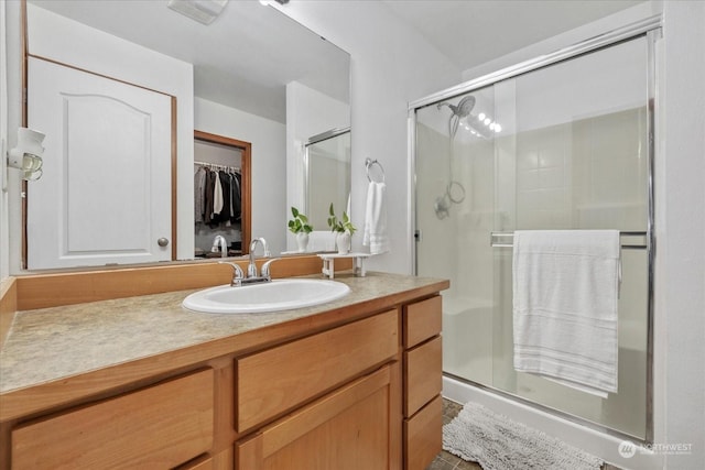 bathroom with vanity and a shower with shower door