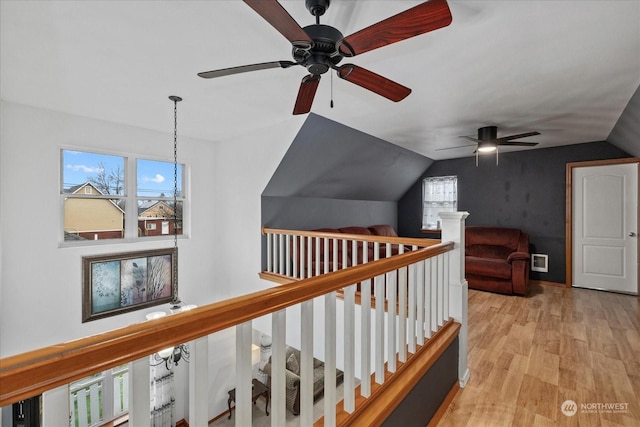 hallway featuring vaulted ceiling and light hardwood / wood-style flooring