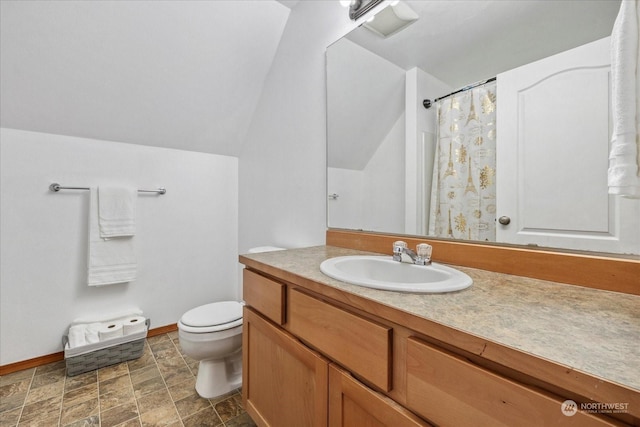 bathroom featuring toilet, vaulted ceiling, and vanity