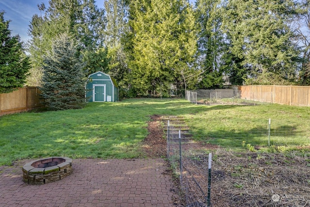 view of yard featuring a shed, an outdoor fire pit, and a patio area