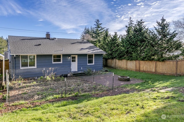 back of house featuring a yard and an outdoor fire pit