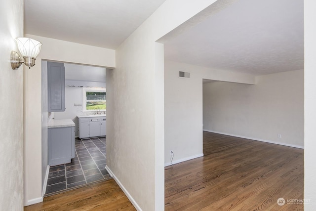 hallway with dark hardwood / wood-style flooring and sink