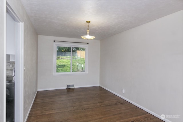 spare room with dark hardwood / wood-style flooring and a textured ceiling